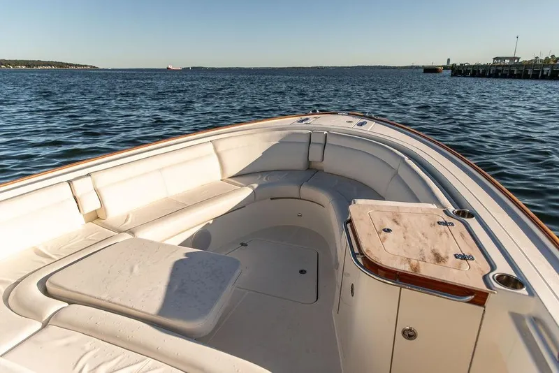 Slide: The Image of 2024 Hinckley Sport Boat 40c cruising on a serene lake with scenic shoreline. - 6