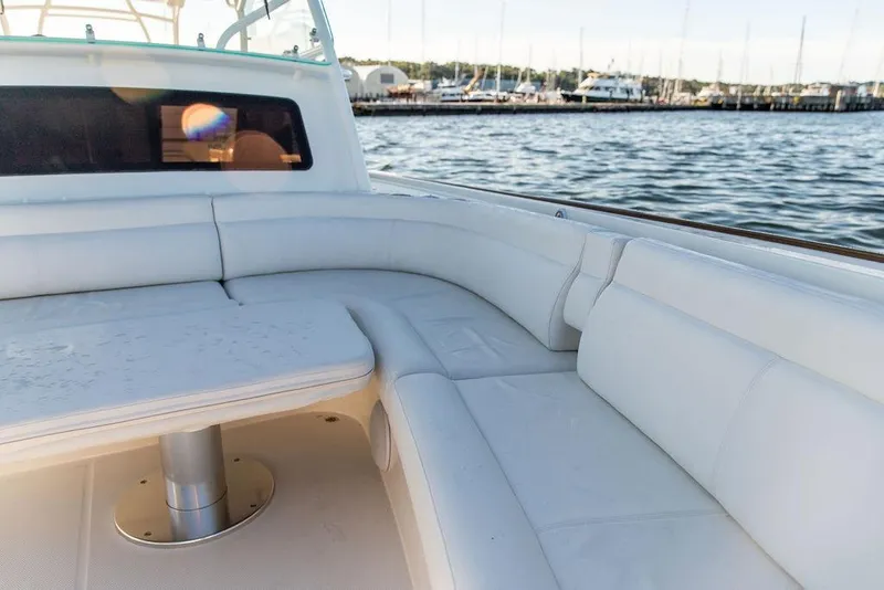 Slide: The Image of 2024 Hinckley Sport Boat 40c cruising on a scenic lake with wooded shoreline. - 8