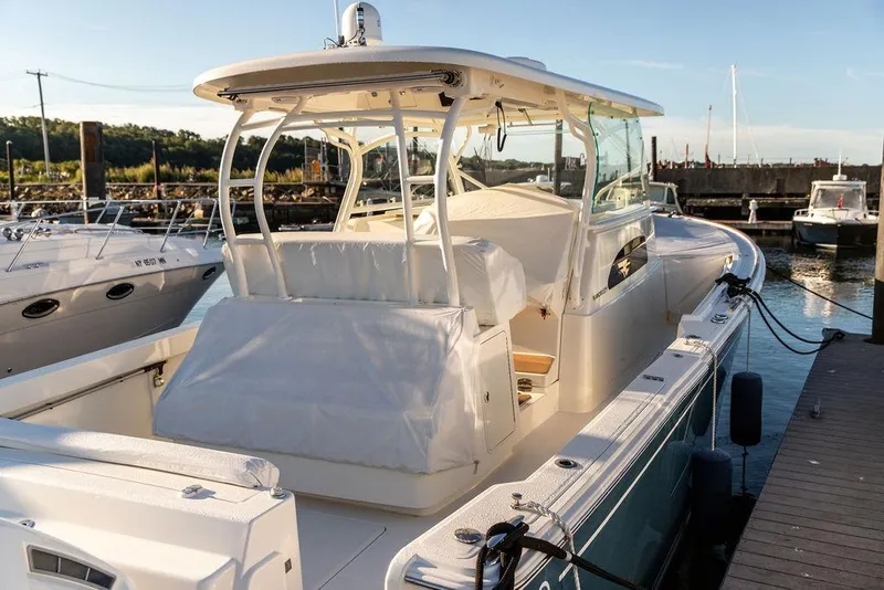 Slide: The Image of 2024 Hinckley Sport Boat 40c, luxurious seating, docked on calm waters. - 10