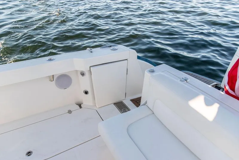 Slide: The Image of 2024 Hinckley Sport Boat 40c with American flag, white seating, and dual engines on water. - 24