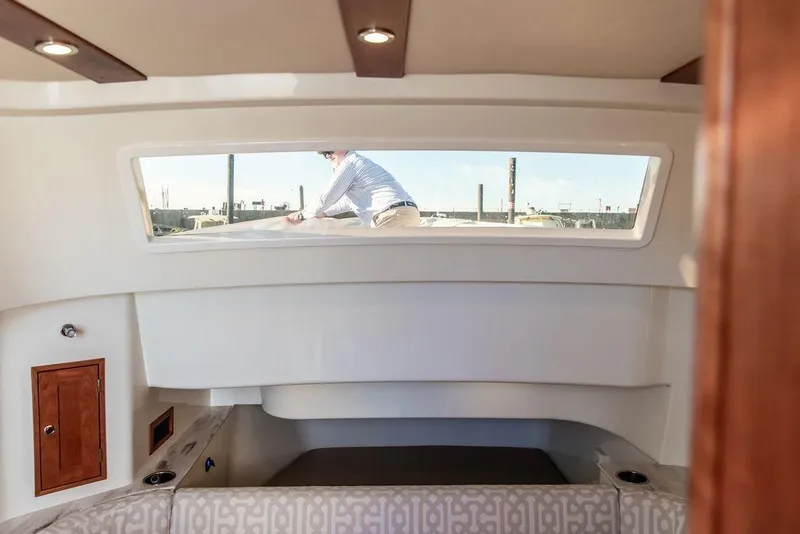 Slide: The Image of Interior view of 2024 Hinckley Sport Boat 40c cabin with window and seating. - 31