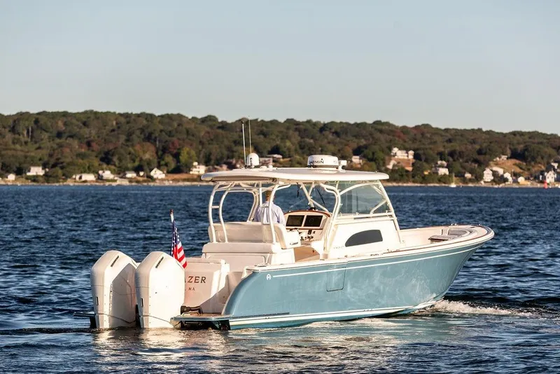 Slide: The Image of 2024 Hinckley Sport Boat 40c cruising on a serene lake with American flag. - 38
