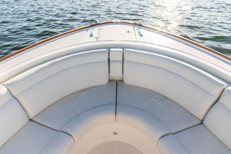 Slide: The Image of 2024 Hinckley Sport Boat 40c cruising on a serene lake with scenic shoreline. - 5