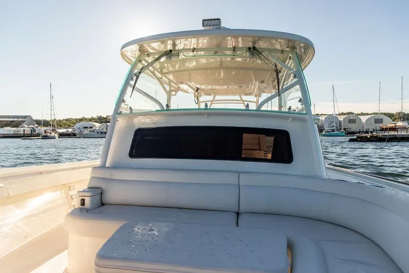 Slide: The Image of 2024 Hinckley Sport Boat 40c cruising on a scenic lake with wooded shoreline. - 7