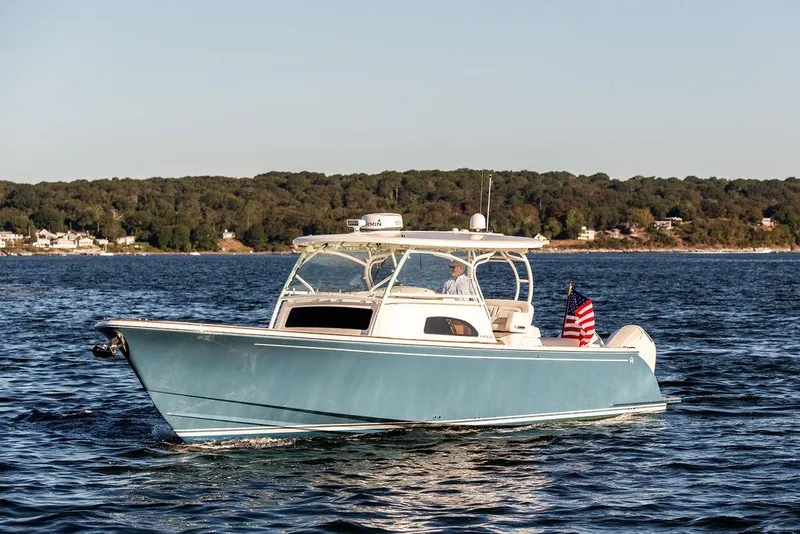 Slide: The Image of 2024 Hinckley Sport Boat 40c with luxurious white seating on calm water. - 9