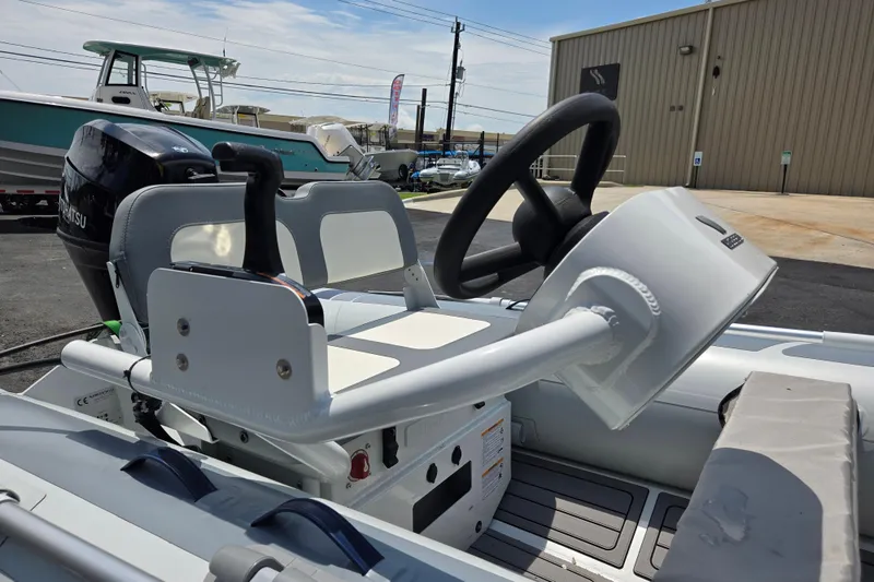 Slide: The Image of 2025 Highfield Classic 360 boat interior with steering wheel and controls, docked outdoors. - 11