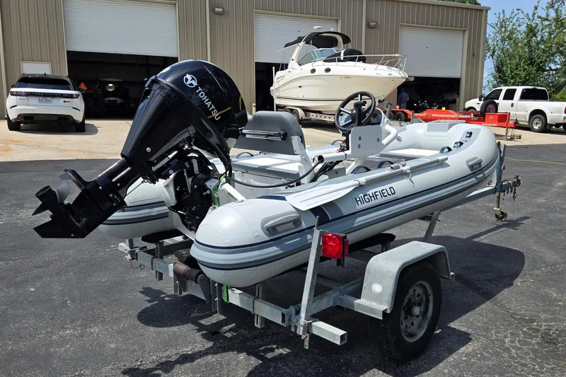 Slide: The Image of 2025 Highfield Classic 360 inflatable boat on trailer with Tohatsu outboard motor. - 3