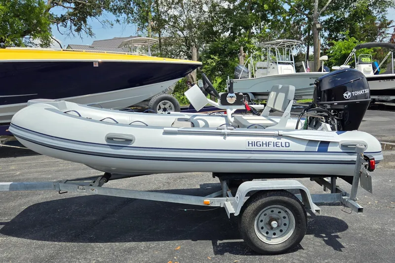 Slide: The Image of 2025 Highfield Classic 360 inflatable boat on trailer with Tohatsu outboard motor. - 7