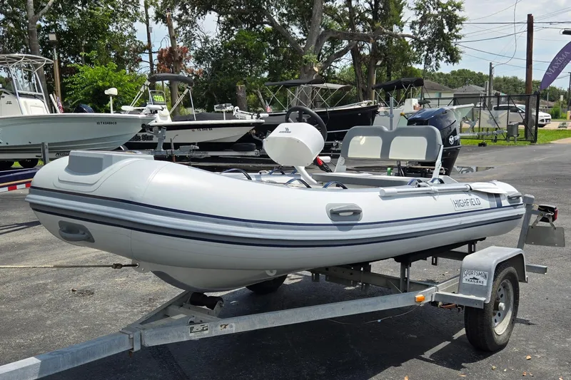 Slide: The Image of 2025 Highfield Classic 360 inflatable boat on trailer, parked outdoors. - 8