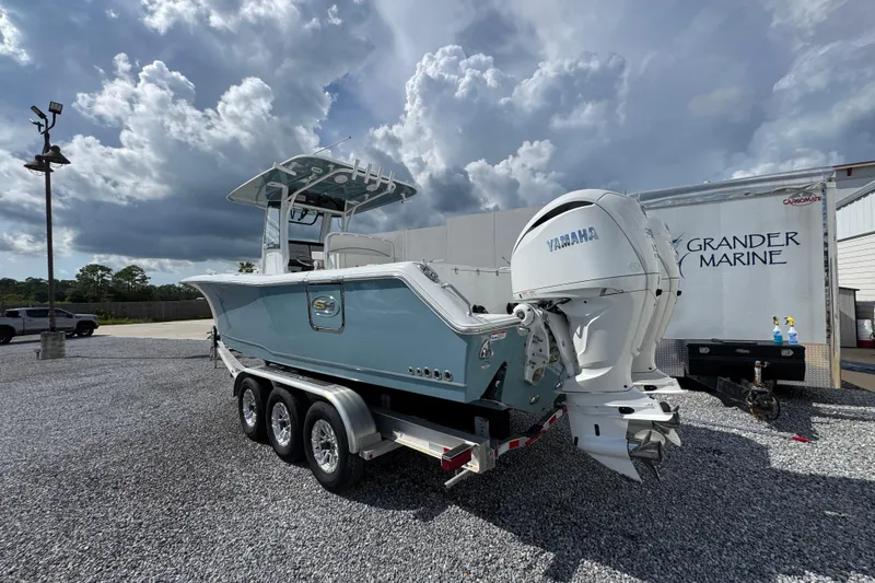 Slide: The Image of 2023 Sea Hunt Gamefish 30 Coffin Box boat with dual Yamaha engines on a trailer. - 15