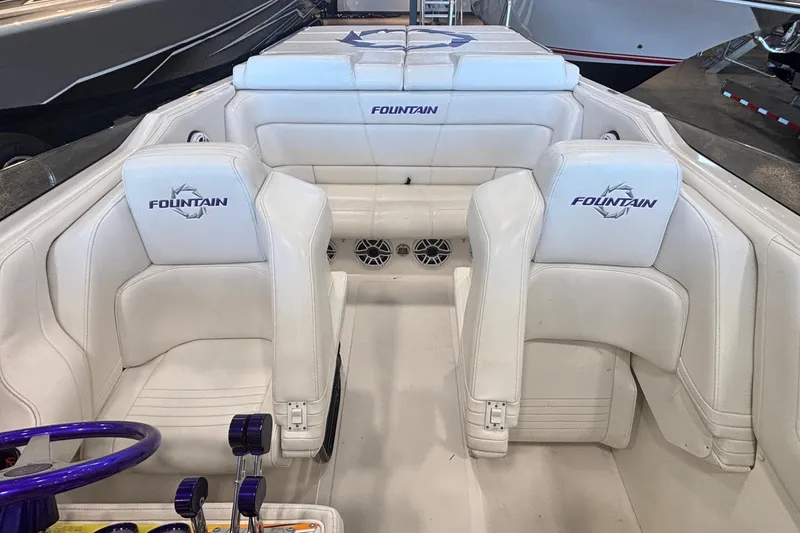 Slide: The Image of 2006 Fountain 42 Executioner boat interior with white seating and purple steering wheel. - 11