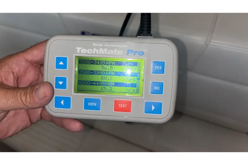 Slide: The Image of Hand holding TechMate Pro diagnostic tool displaying RPM data for 2006 Fountain 42 Executioner. - 26