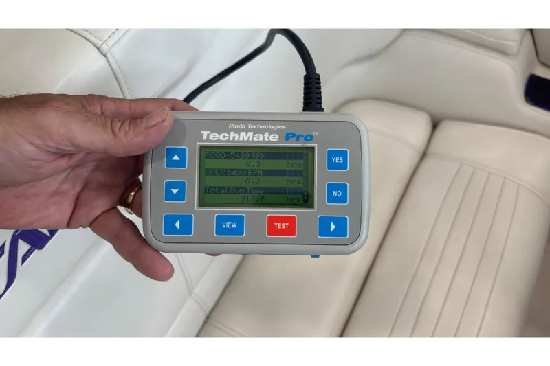 Slide: The Image of Hand holding TechMate Pro diagnostic tool inside 2006 Fountain 42 Executioner boat. - 31