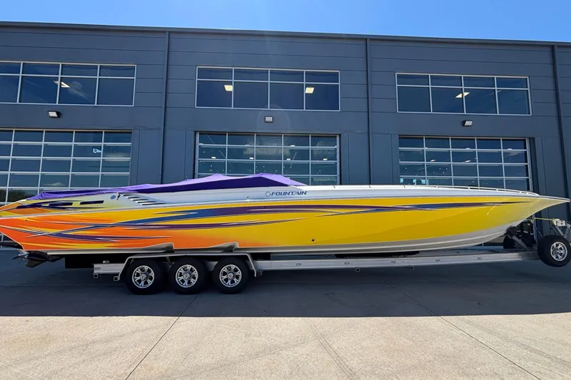 Slide: The Image of 2006 Fountain 42 Executioner speedboat with vibrant yellow and orange design on a trailer. - 32