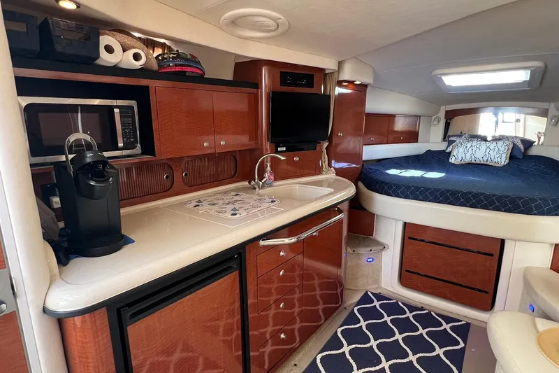 Slide: The Image of 2005 Sea Ray 340 Sundancer interior with kitchenette, bed, and modern amenities. - 12