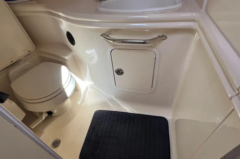 Slide: The Image of 2005 Sea Ray 340 Sundancer bathroom with toilet, sink, and storage compartment. - 13