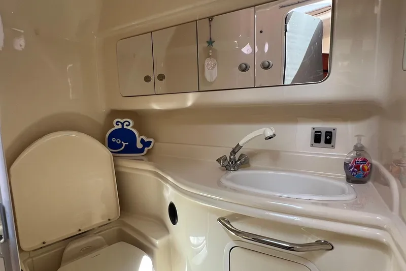 Slide: The Image of 2005 Sea Ray 340 Sundancer bathroom with sink, mirror, and storage cabinets. - 14