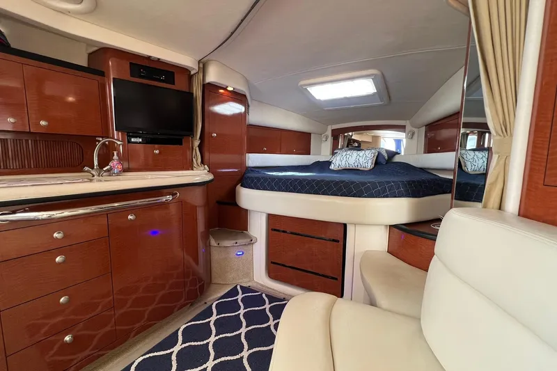 Slide: The Image of 2005 Sea Ray 340 Sundancer interior with luxurious wood cabinetry and cozy sleeping area. - 18
