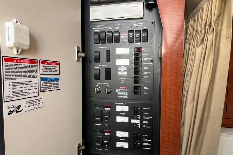Slide: The Image of Electrical control panel inside 2005 Sea Ray 340 Sundancer boat, featuring various switches and warnings. - 21