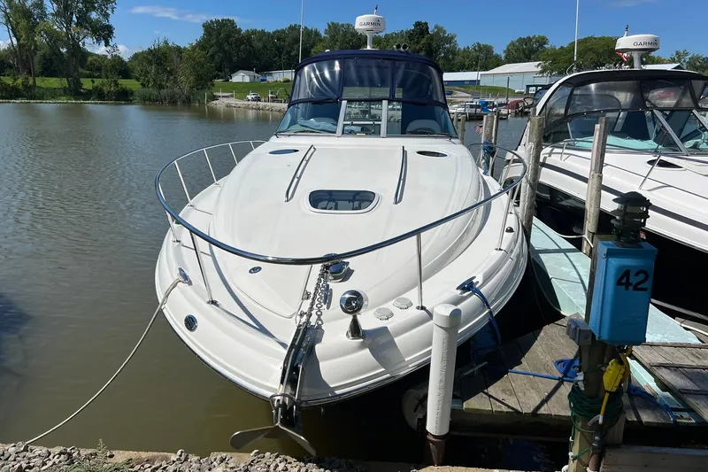 Slide: The Image of 2005 Sea Ray 340 Sundancer docked at marina, surrounded by calm water and greenery. - 29