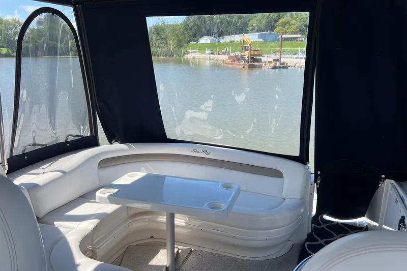 Slide: The Image of 2005 Sea Ray 340 Sundancer interior with seating and table, overlooking a serene waterfront. - 5