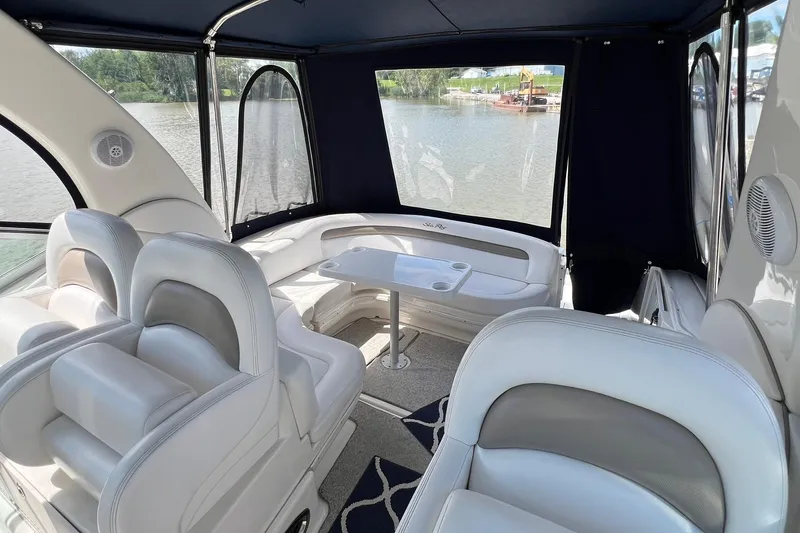 Slide: The Image of 2005 Sea Ray 340 Sundancer interior with white seating and table, overlooking water. - 7