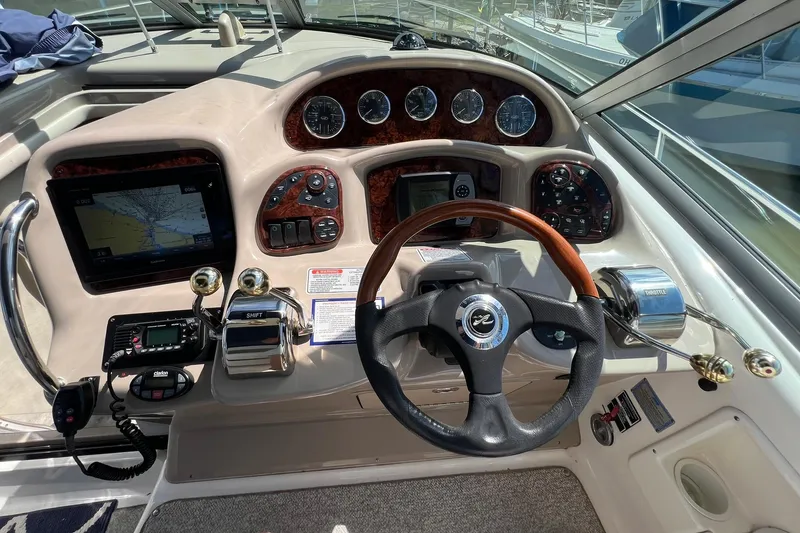 Slide: The Image of 2005 Sea Ray 340 Sundancer helm with navigation controls and steering wheel. - 8