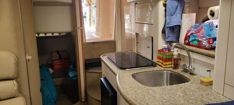 Slide: The Image of Interior of a 1998 Maxum 3000 SCR boat, featuring a compact kitchen area. - 13