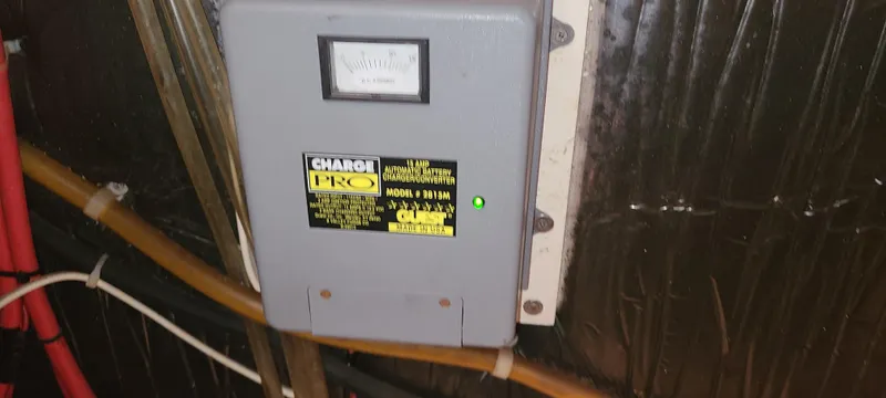 Slide: The Image of Electrical panel in a 1998 Maxum 3000 SCR boat, featuring a Charge Pro device. - 21