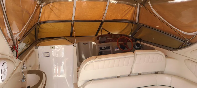 Slide: The Image of 1998 Maxum 3000 SCR boat interior with beige seating and covered helm area. - 5
