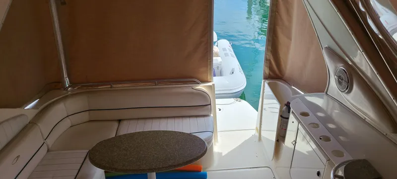 Slide: The Image of 1998 Maxum 3000 SCR boat interior with seating, table, and view of water. - 7