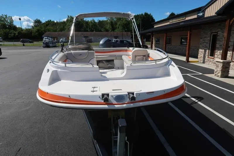Slide: The Image of 2020 Starcraft MDX OB 211 E OB boat, white and orange, parked outside a building. - 6
