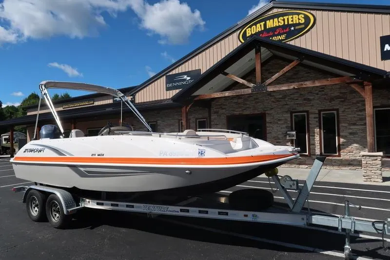 Slide: The Image of 2020 Starcraft MDX OB 211 E OB boat on trailer outside dealership. - 8