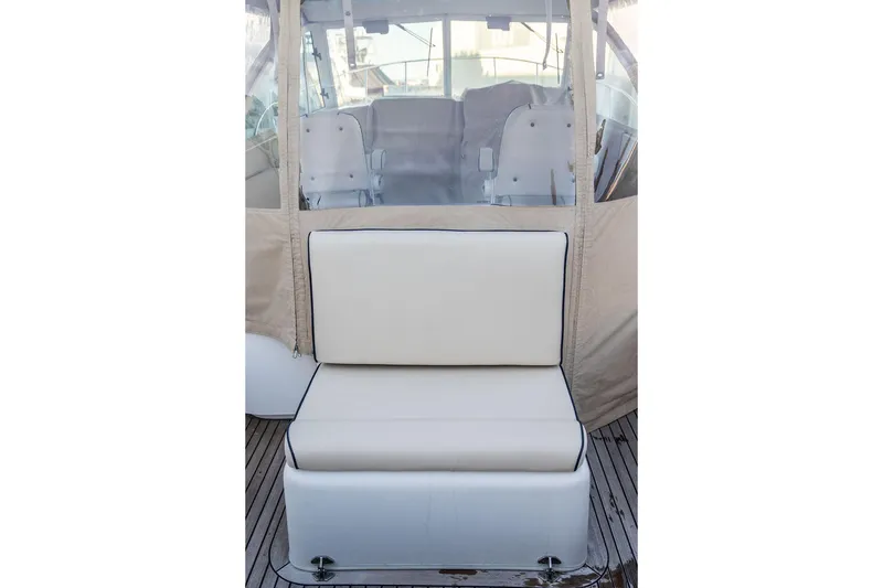 Slide: The Image of 2008 Hunt Yachts Surfhunter 29 interior seating with beige cushions and clear enclosure. - 12