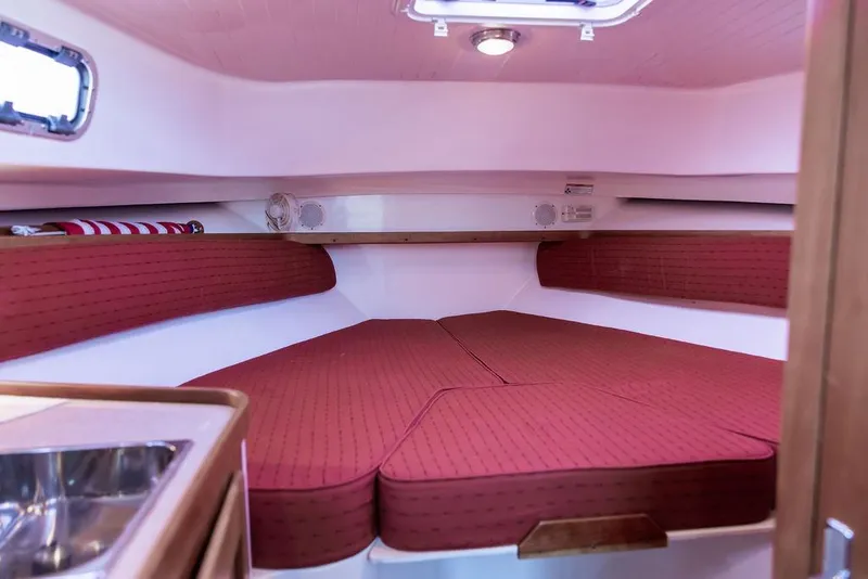 Slide: The Image of 2008 Hunt Yachts Surfhunter 29 cabin with red cushions and compact sink. - 14
