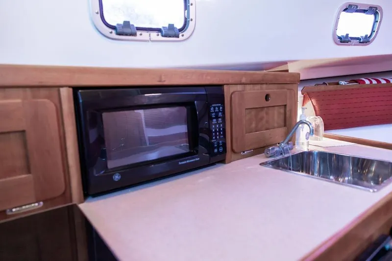 Slide: The Image of 2008 Hunt Yachts Surfhunter 29 interior with microwave and sink in wooden cabinetry. - 15