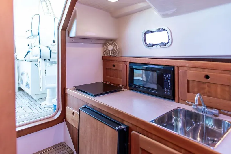 Slide: The Image of 2008 Hunt Yachts Surfhunter 29 interior with kitchenette, microwave, and sink. - 17