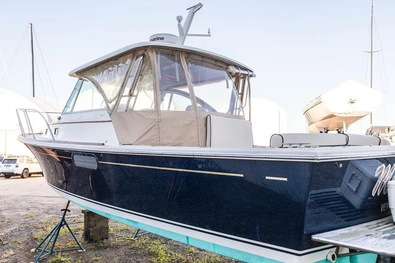 Slide: The Image of 2008 Hunt Yachts Surfhunter 29 boat on stands, featuring a sleek navy hull. - 3