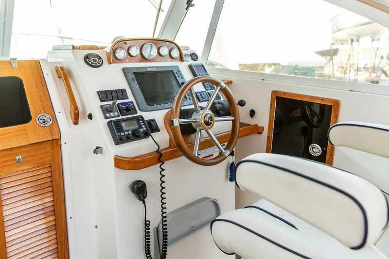 Slide: The Image of 2008 Hunt Yachts Surfhunter 29 helm with wooden accents and modern navigation equipment. - 7