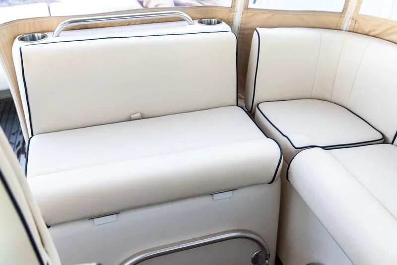 Slide: The Image of 2008 Hunt Yachts Surfhunter 29 interior seating with cream upholstery and cup holders. - 11