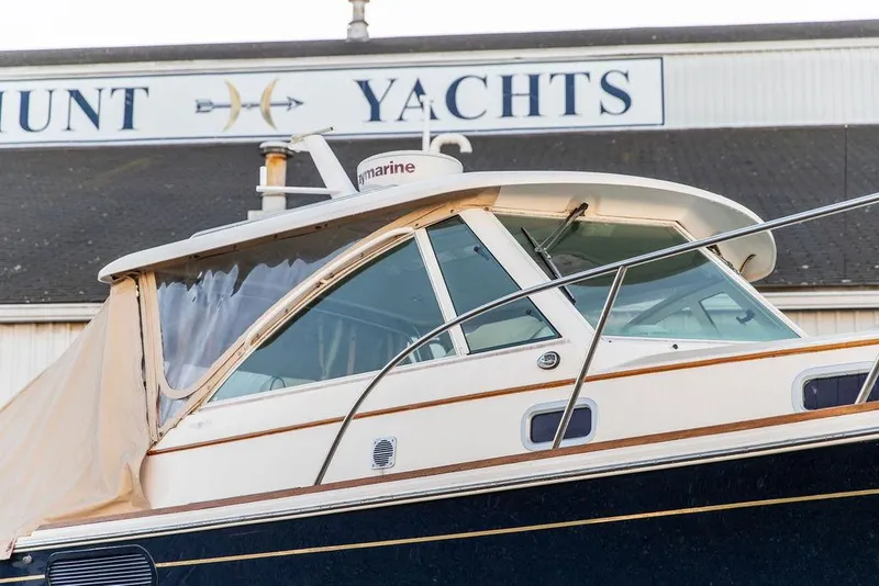 Slide: The Image of 2008 Hunt Yachts Surfhunter 29 boat at dockside, featuring sleek design and cabin enclosure. - 2