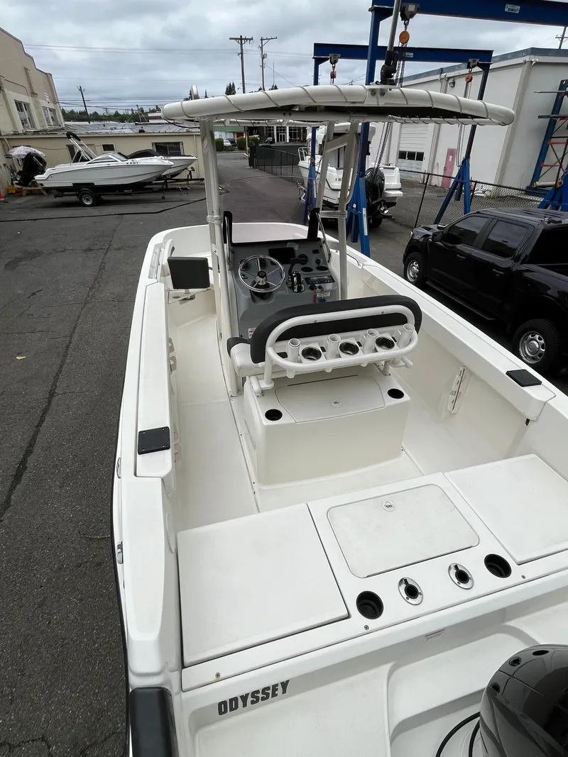 Slide: The Image of 2021 Bayliner Trophy boat with center console and rod holders, parked in a marina. - 13