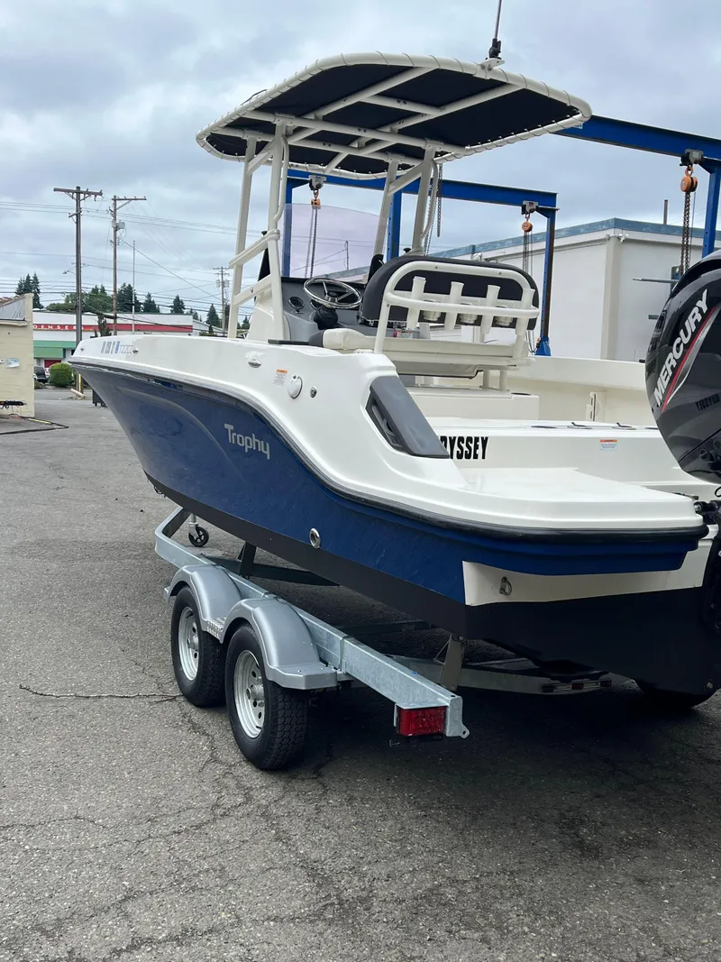 Slide: The Image of 2021 Bayliner Trophy boat on trailer, featuring a Mercury engine, parked outdoors. - 16