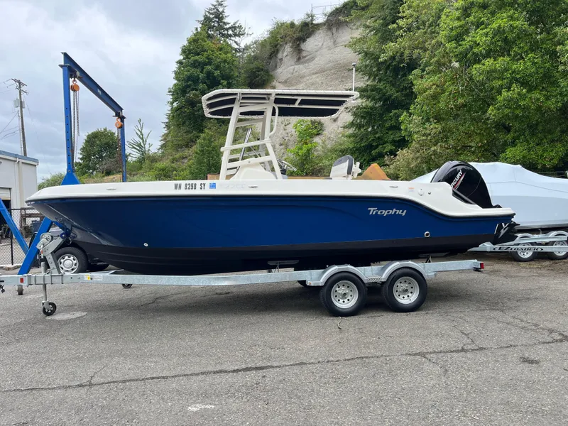 Slide: The Image of 2021 Bayliner Trophy boat on trailer, blue hull, parked outdoors. - 18