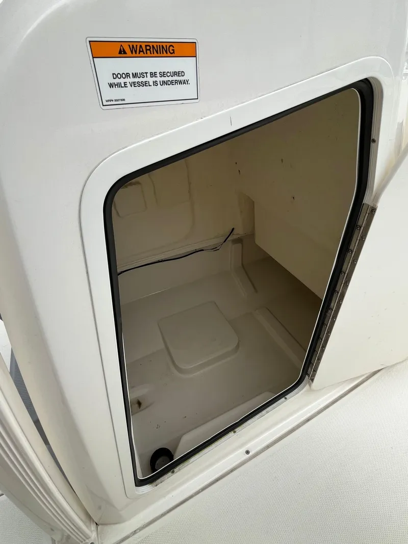 Slide: The Image of Bayliner Trophy 2021 boat compartment with warning sign, open door view. - 4