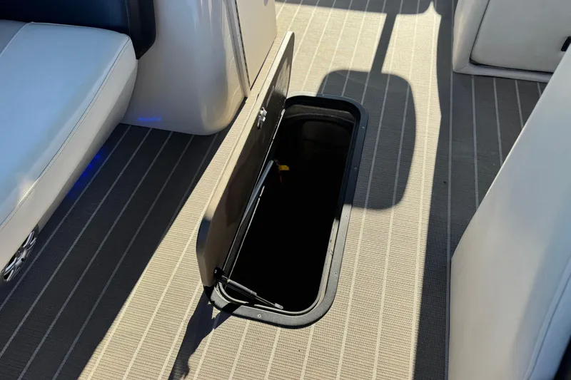 Slide: The Image of Open storage compartment on 2021 Manitou 23 Aurora LE Standard boat deck. - 13