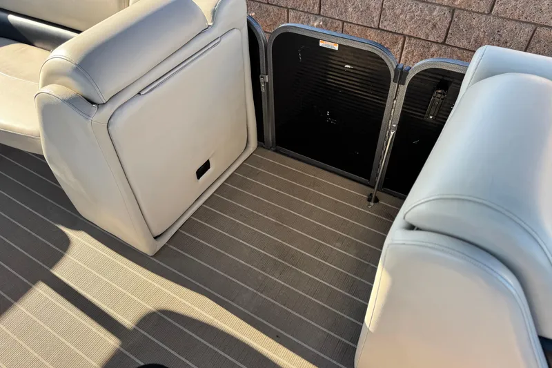 Slide: The Image of 2021 Manitou 23 Aurora LE Standard boat interior with gray seating and striped flooring. - 14