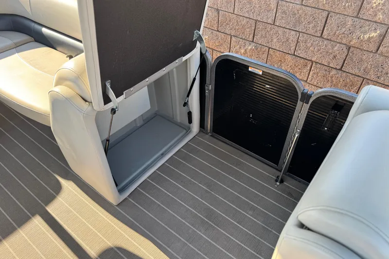 Slide: The Image of 2021 Manitou 23 Aurora LE Standard boat interior storage compartment open. - 15