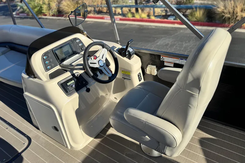 Slide: The Image of 2021 Manitou 23 Aurora LE Standard boat cockpit with steering wheel and control panel. - 22