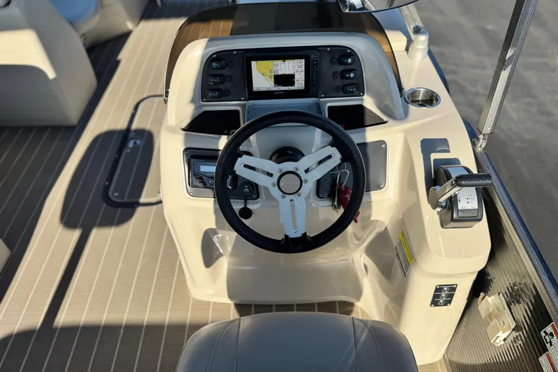 Slide: The Image of 2021 Manitou 23 Aurora LE Standard boat dashboard with steering wheel and controls. - 23